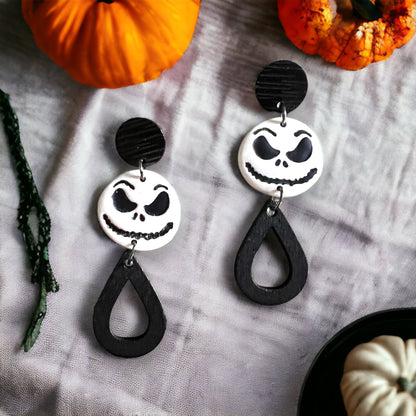 Black and White “Jack” dangle earrings featuring spooky face charms and teardrop accents. Perfect for adding a touch of Halloween spirit to any outfit.