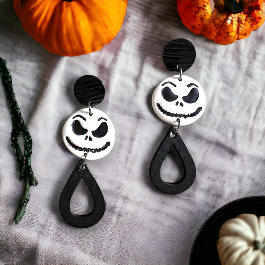 Black and White “Jack” dangle earrings featuring spooky face charms and teardrop accents. Perfect for adding a touch of Halloween spirit to any outfit.