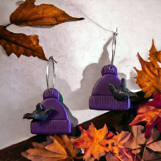 Handmade purple beanie polymer clay earrings with bat accents. Designed for fall outfits, capturing cozy autumn charm. 
