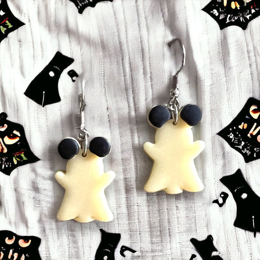 White, glow-in-the-dark dangle earrings shaped like playful ghost mice with black ears, shown on an earring card for Halloween charm.