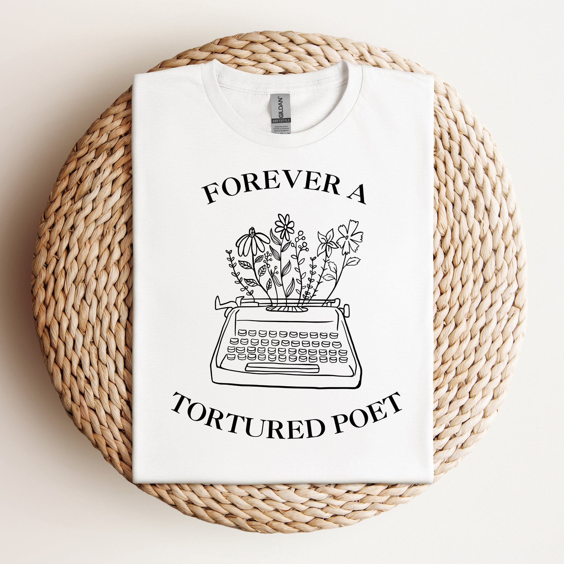White t-shirt with a black line art of a typewriter with flowers and the text "Forever a Tortured Poet," inspired by the Tortured Poets album.