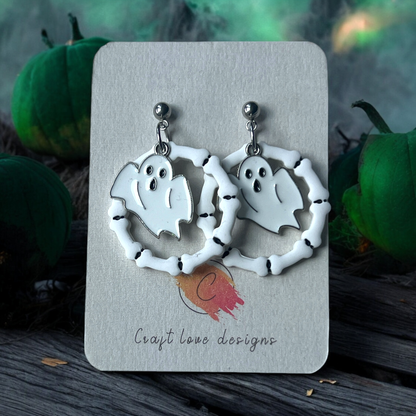 Polymer clay ghost earrings framed by bone hoops, displayed on Craft Love Designs card with a spooky green and pumpkin background.