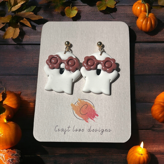 White ghost earrings with floral glasses on a Craft Love Designs display card, surrounded by small pumpkins and cozy fall decor.