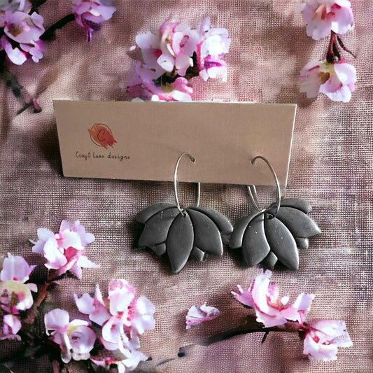 Earrings displayed on a soft, floral background, emphasizing their nature-inspired design.