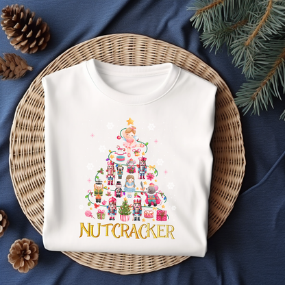 Flat lay of a white Nutcracker-themed Christmas t-shirt featuring festive characters like Clara, nutcrackers, and holiday decor.
