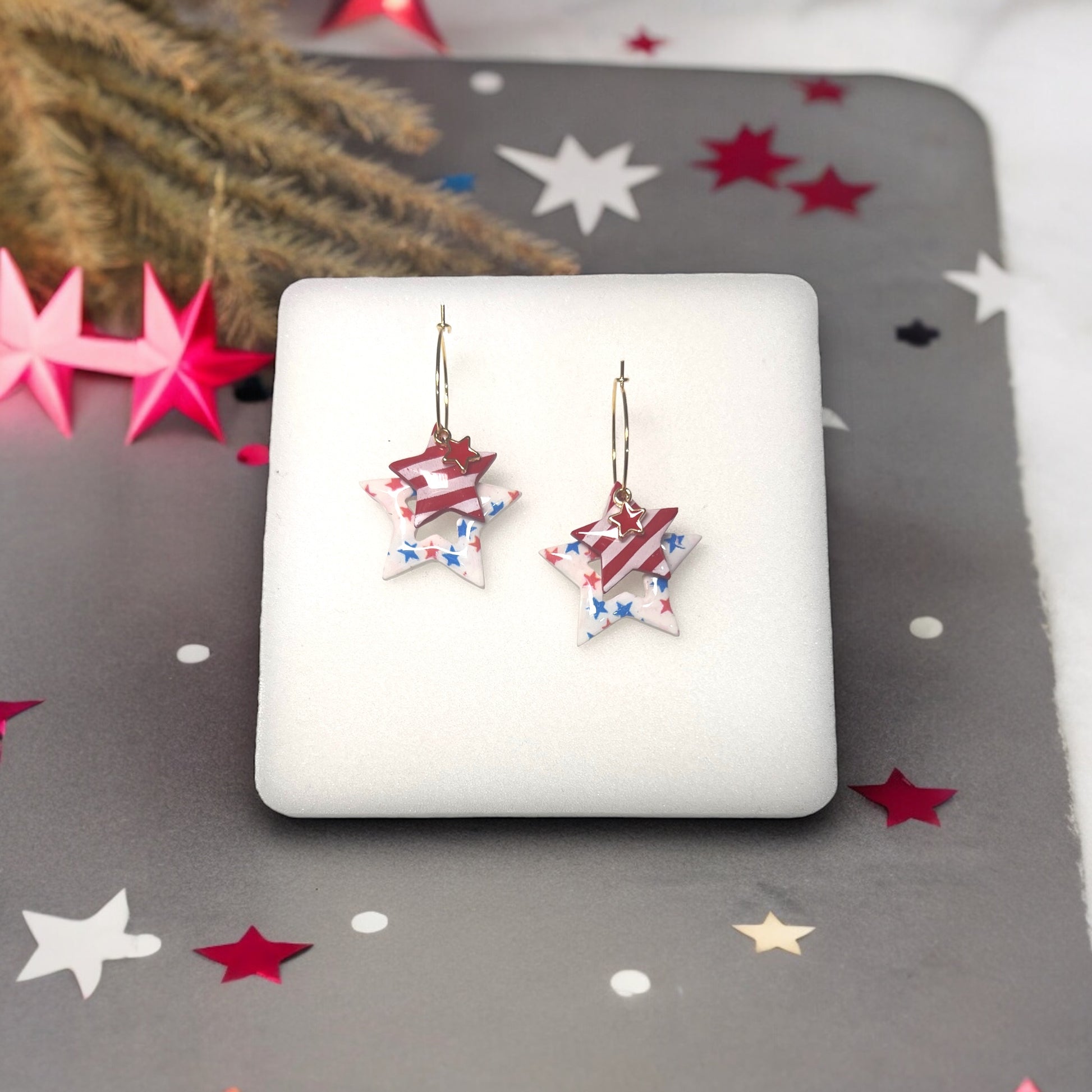 Handmade patriotic star dangle earrings featuring red stripes, blue stars, and gold accents, perfect for 4th of July celebrations.