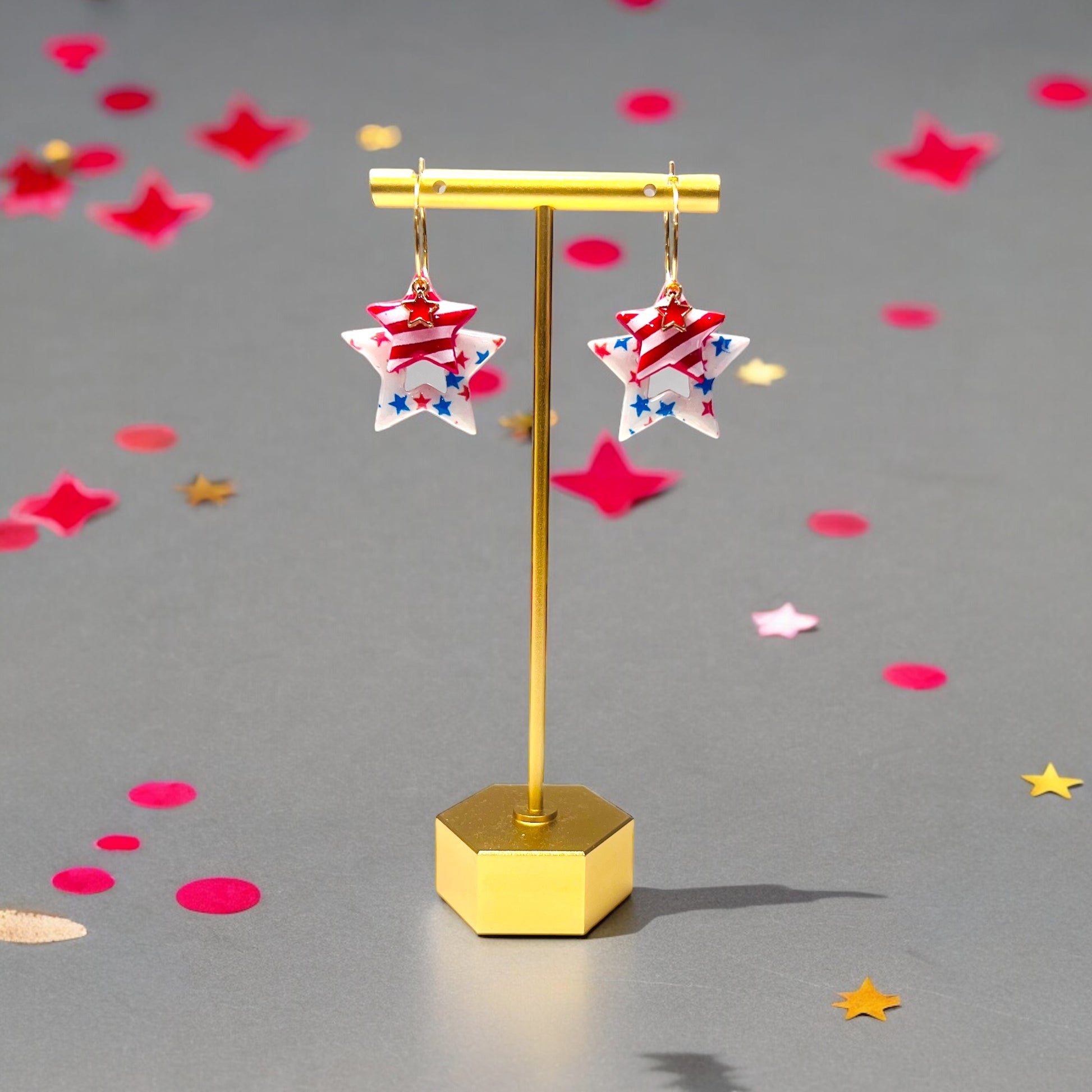 Red, white, and blue star earrings featuring bold patterns and gold accents, designed for patriotic events or summer celebrations.