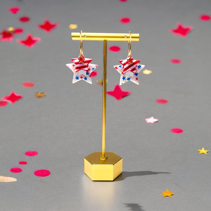 Red, white, and blue star earrings featuring bold patterns and gold accents, designed for patriotic events or summer celebrations.