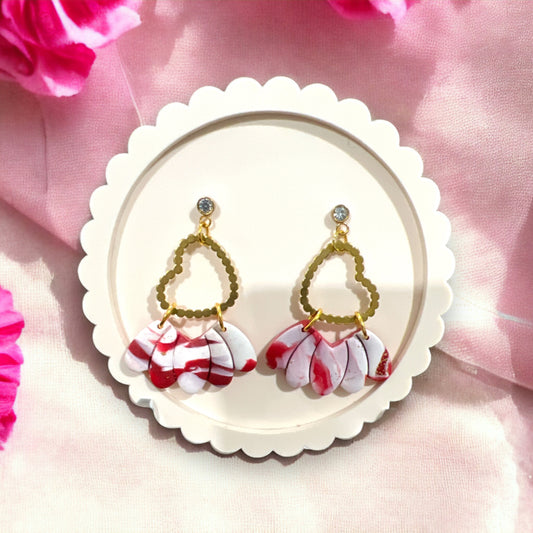 Elegant red and white dangle earrings with heart-shaped gold accents, perfect for festive events or accessorizing romantic outfits.