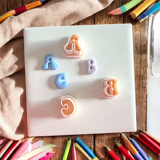 Colorful letter-shaped erasers on a white board with colorful pencils around.