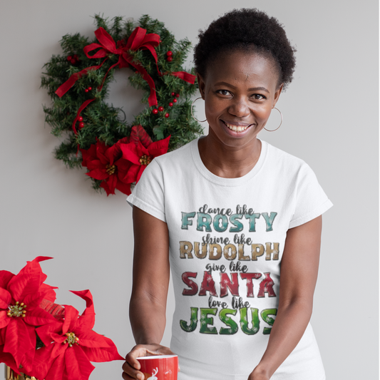 Woman wearing a white holiday t-shirt with colorful text highlighting Christmas characters like Frosty, Rudolph, Santa, and Jesus.