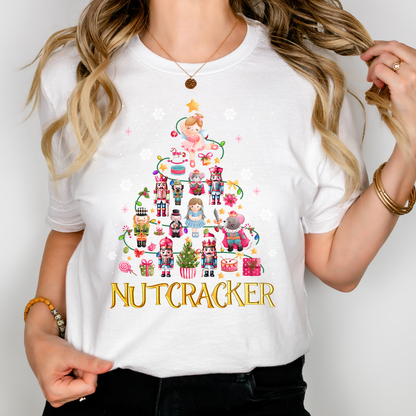 Woman wearing a white Nutcracker-themed Christmas t-shirt decorated with festive characters like Clara, nutcrackers, and a holiday tree.