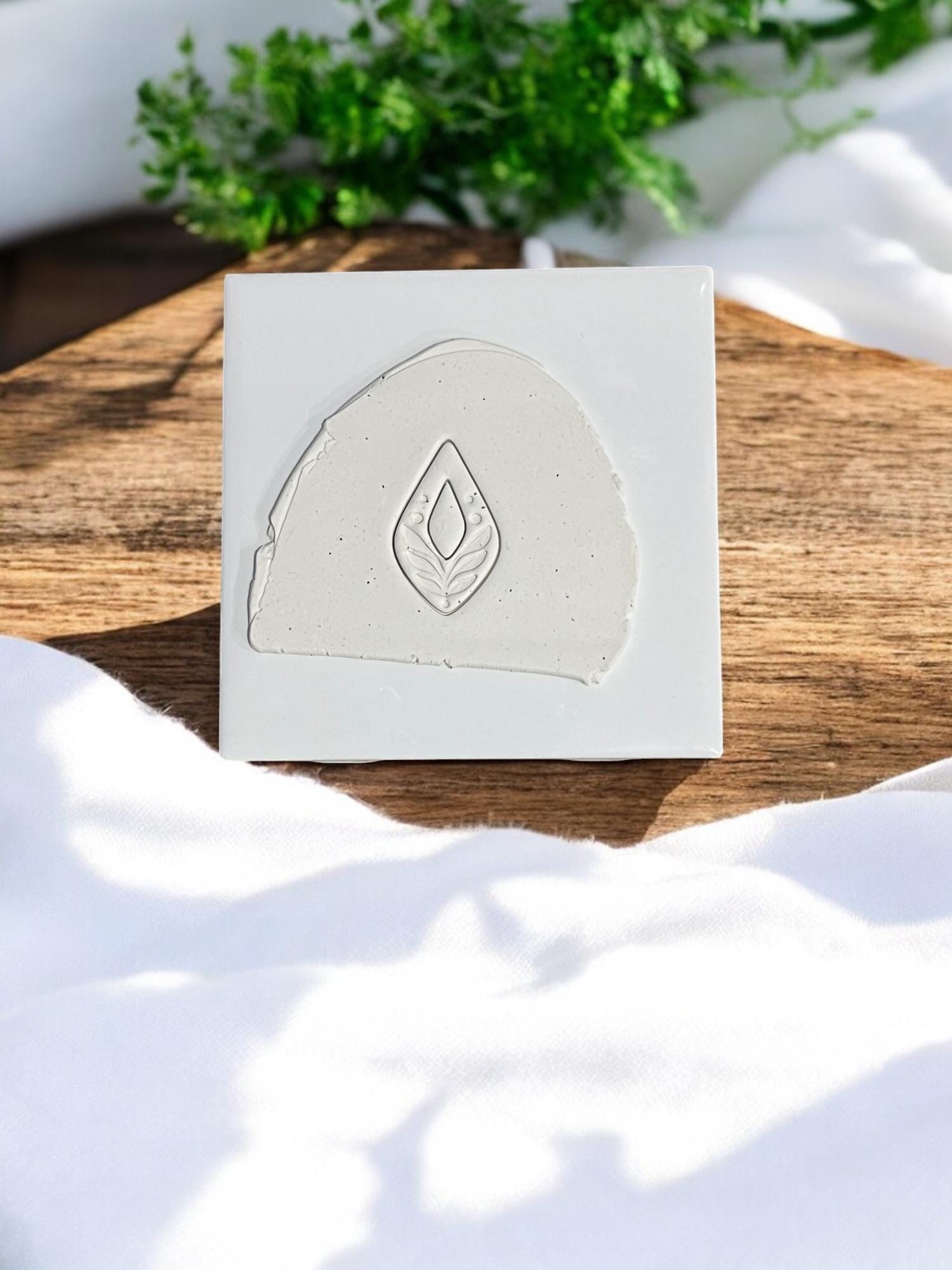 Pressed clay slab featuring drop-shaped leaf design in natural light