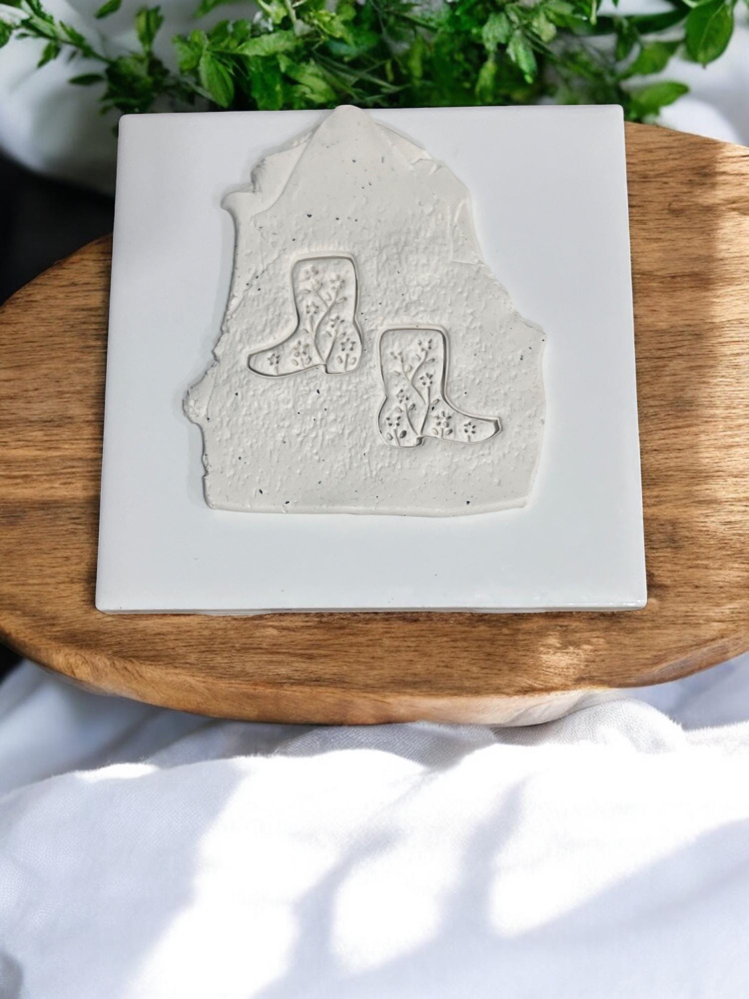 Western boot emboss design pressed into clay slab on ceramic tile