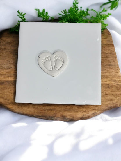 Finished clay piece showing heart shape with embossed footprints
