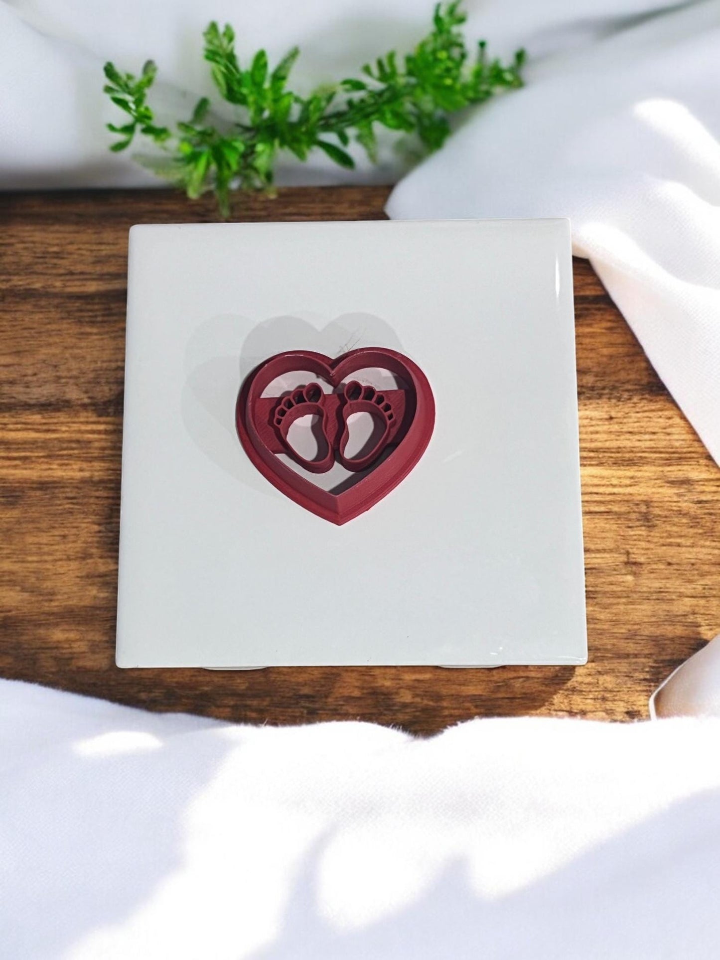 Overhead view of heart and footprint cutter placed on ceramic tile