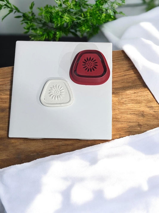 Clay cutter next to embossed clay showing design clarity