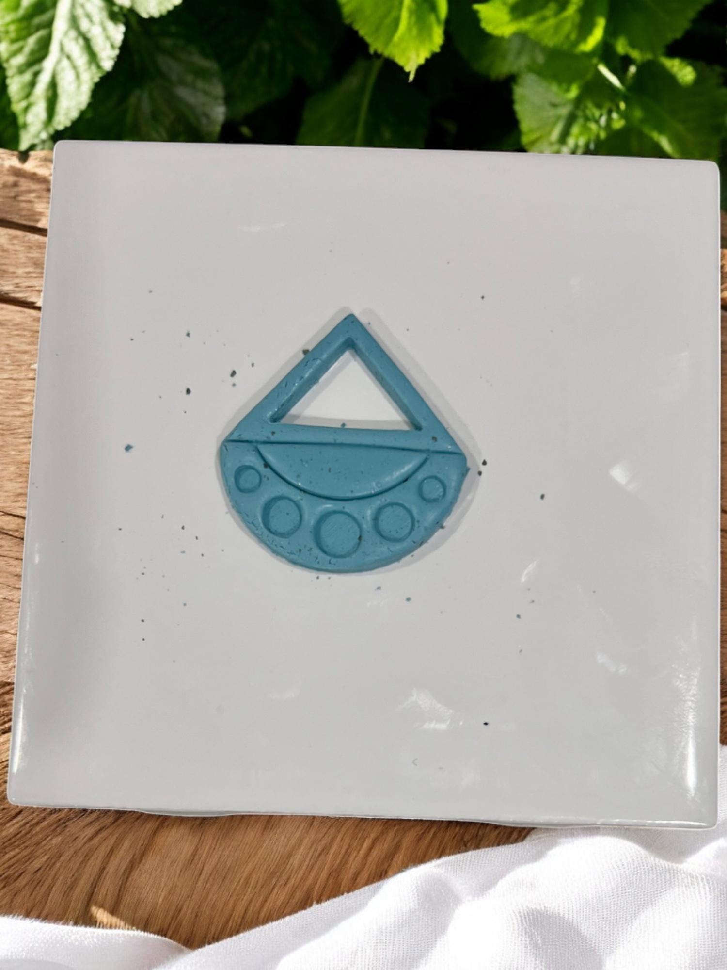Cut blue clay shape showing triangle and dot cutouts from boho drop cutter