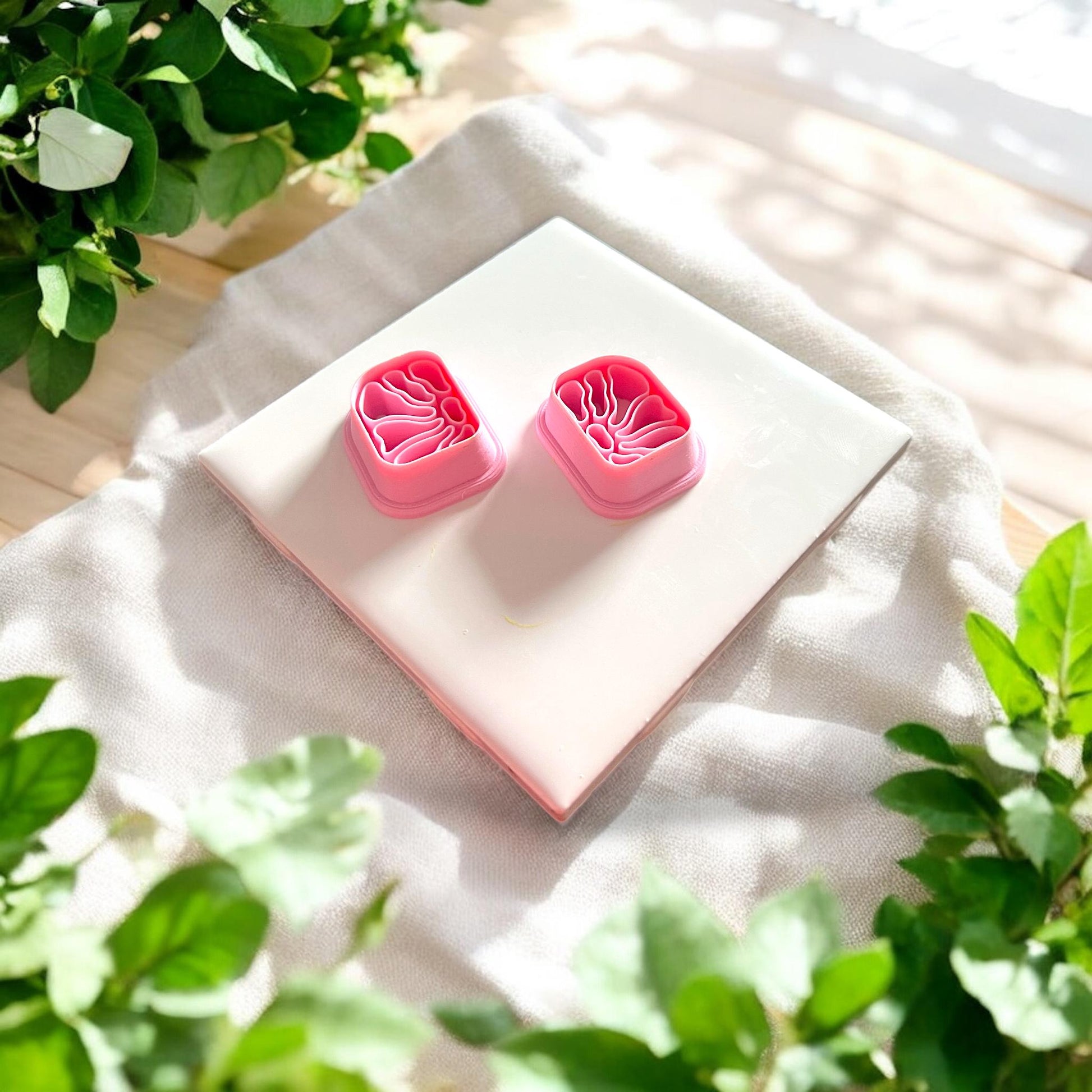 mirrored floral clay cutter pair on white tile