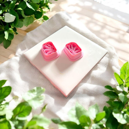 mirrored floral clay cutter pair on white tile