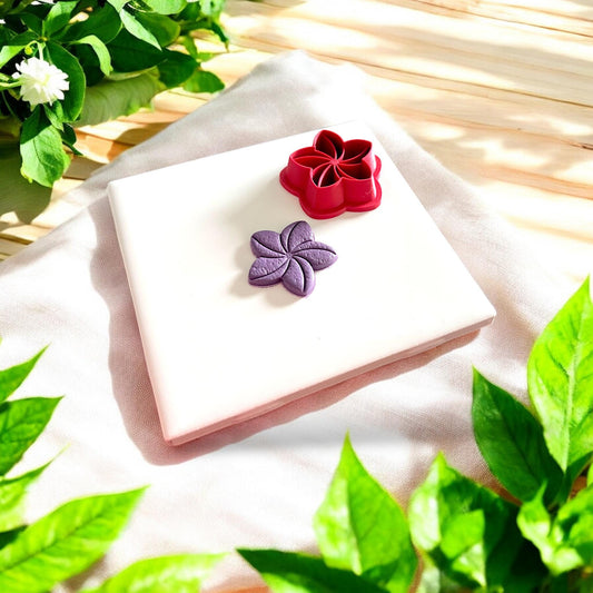 purple flower with red plumeria cutter beside