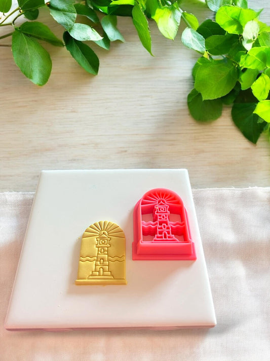 Pink 3D printed lighthouse polymer clay cutter in an arched frame design for creating scenic summer coastal jewelry pieces