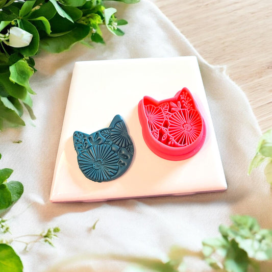 Polymer clay cutter shaped like a cat adorned with floral elements, perfect for earrings and charms.