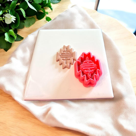 Boot stitch polymer clay cutter next to finished shape, shown on display-ready surface