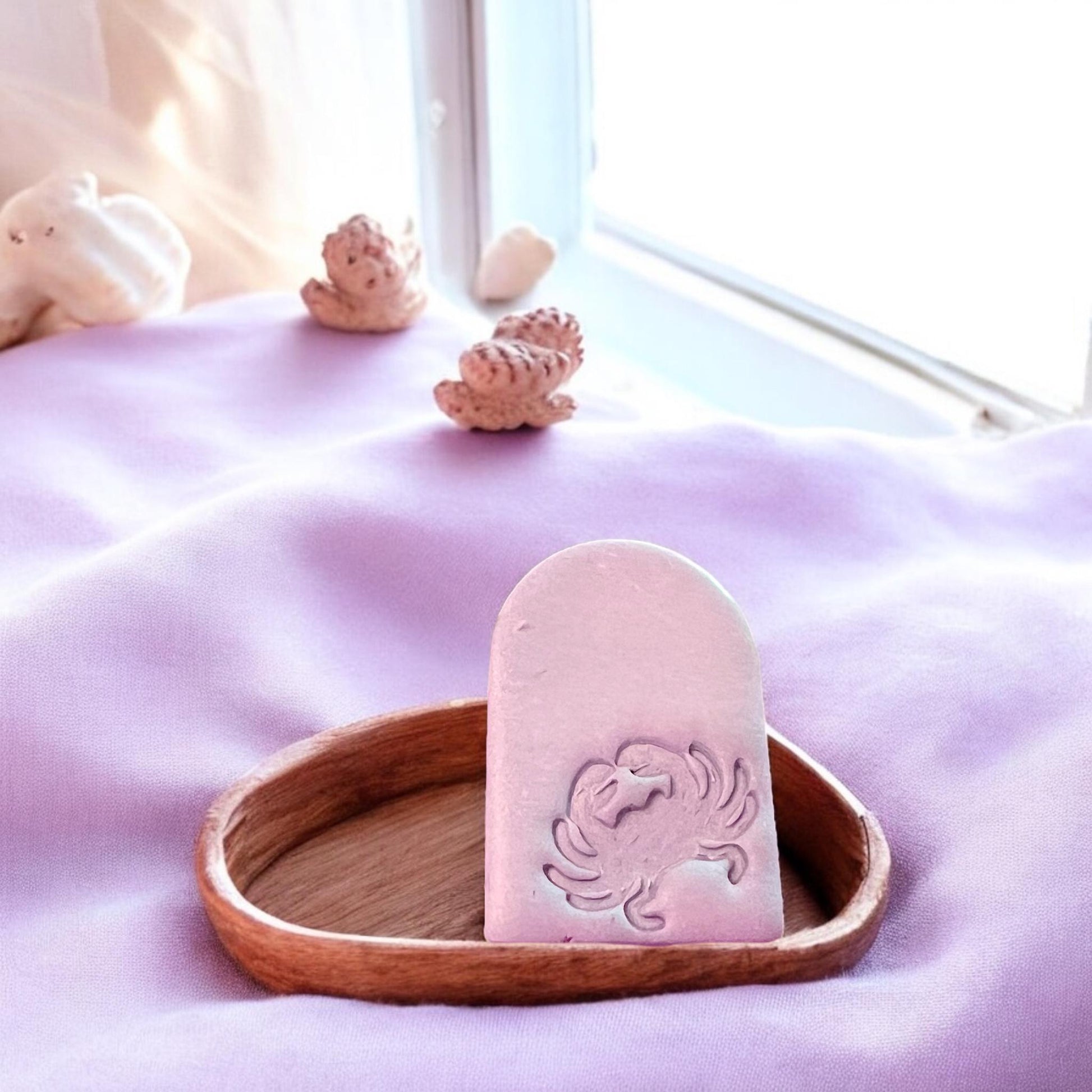 Coastal-styled crab arch earring piece placed on a wooden dish with seashell props, perfect for beach vibes.