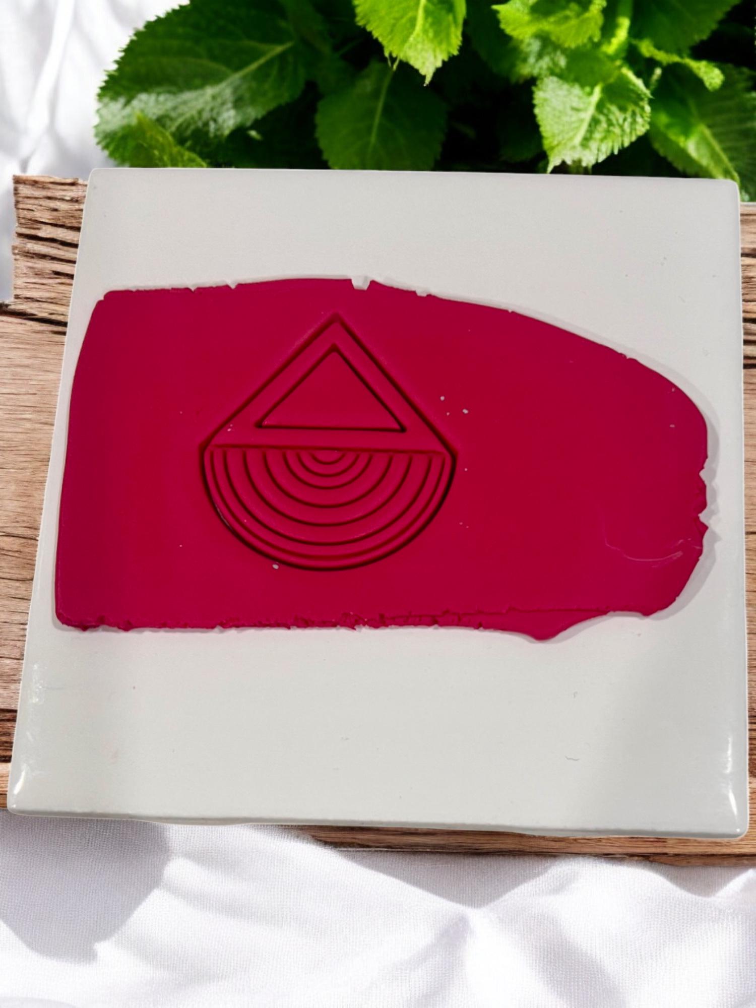Pressed geometric design in deep red clay on ceramic tile