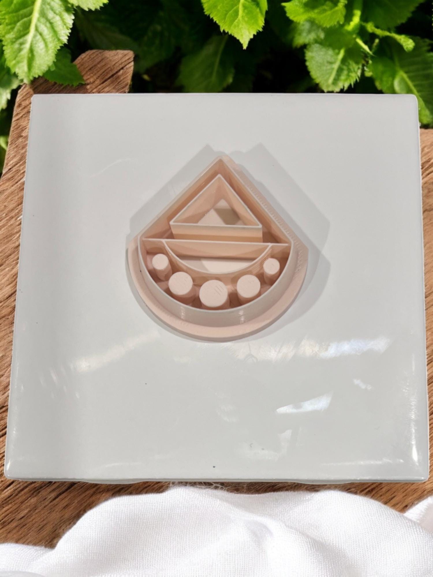 Nude PLA geometric clay cutter with modern triangle and half-moon design on tile