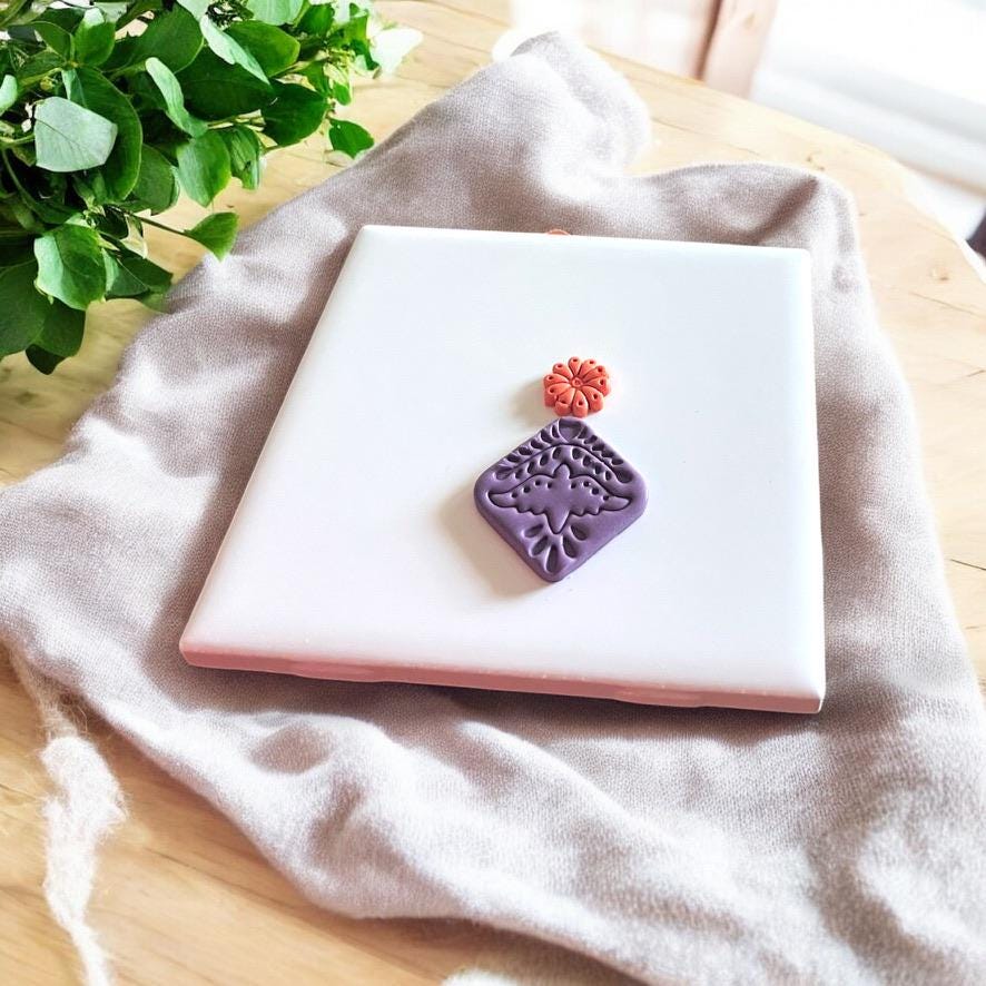 Close-up of an Aztec-inspired bird clay stamp impression, ideal for boho and tribal-style polymer clay earrings
