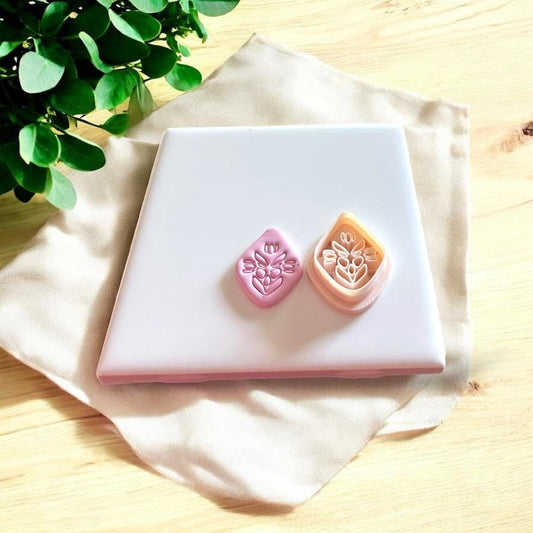 Side-by-side image of the folk art flower clay piece with the matching polymer clay cutter in pastel peach