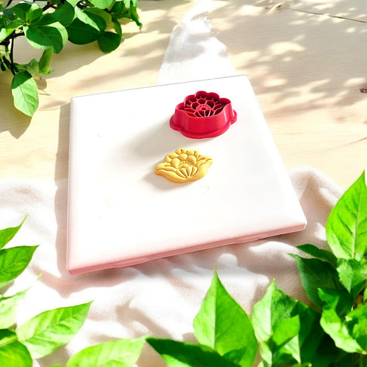 floral clay piece beside red cutter