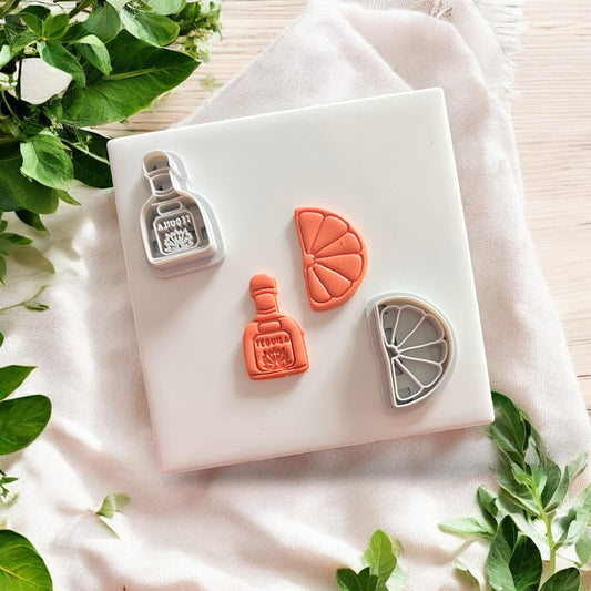 Finished tequila and lime clay earring pieces on white background