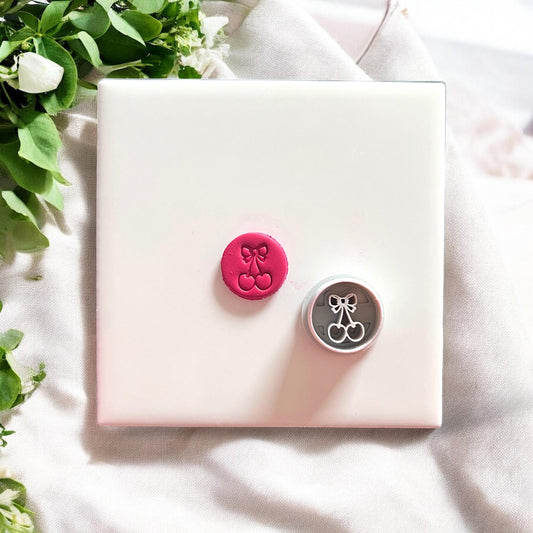 Cherry bow cutter and finished clay earring piece on tile