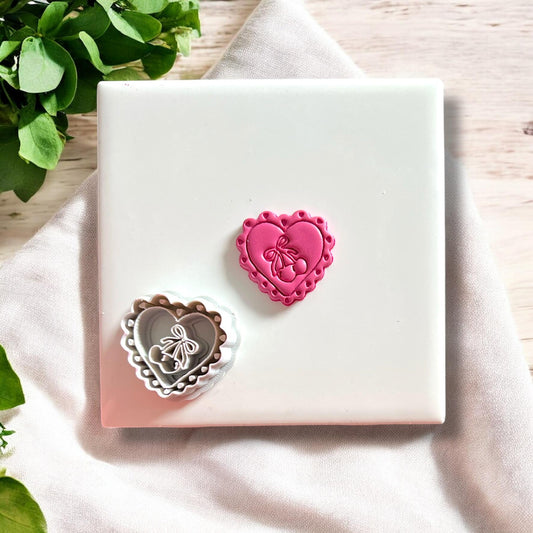 Polymer clay cutout shown next to the matching coquette heart cherry bow cutter