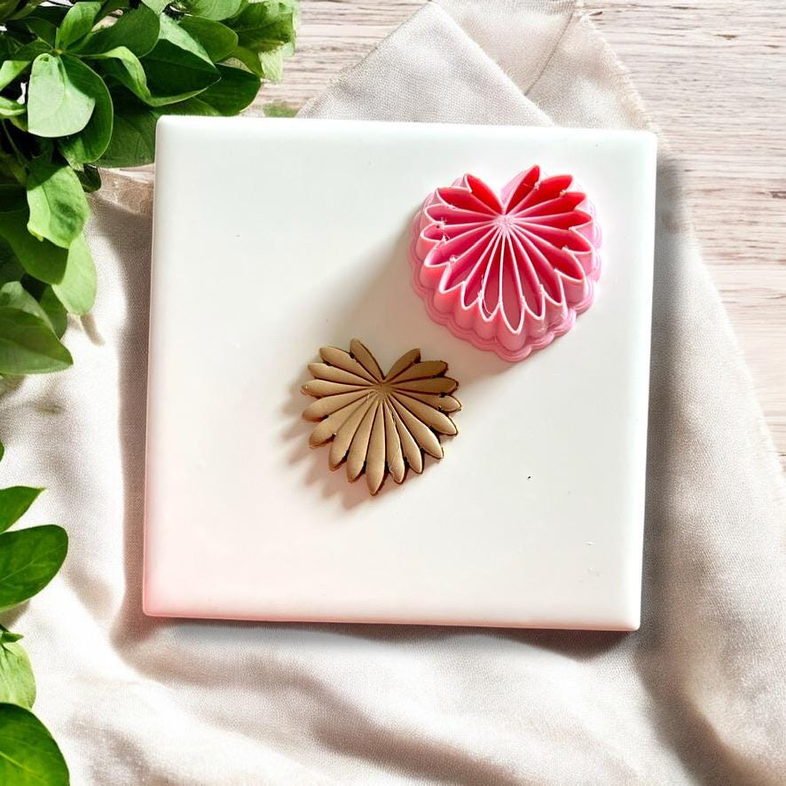 Palm leaf clay cutter next to a finished clay piece in leaf design