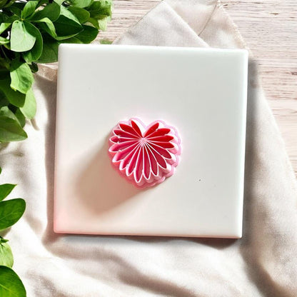 Top view of pink palm leaf polymer clay cutter shown on tile surface