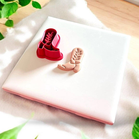 cowboy boot clay piece with red cutter beside it