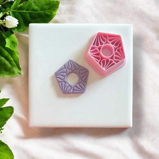 Completed polymer clay earrings made using the floral motif cutter, displayed on a neutral background.