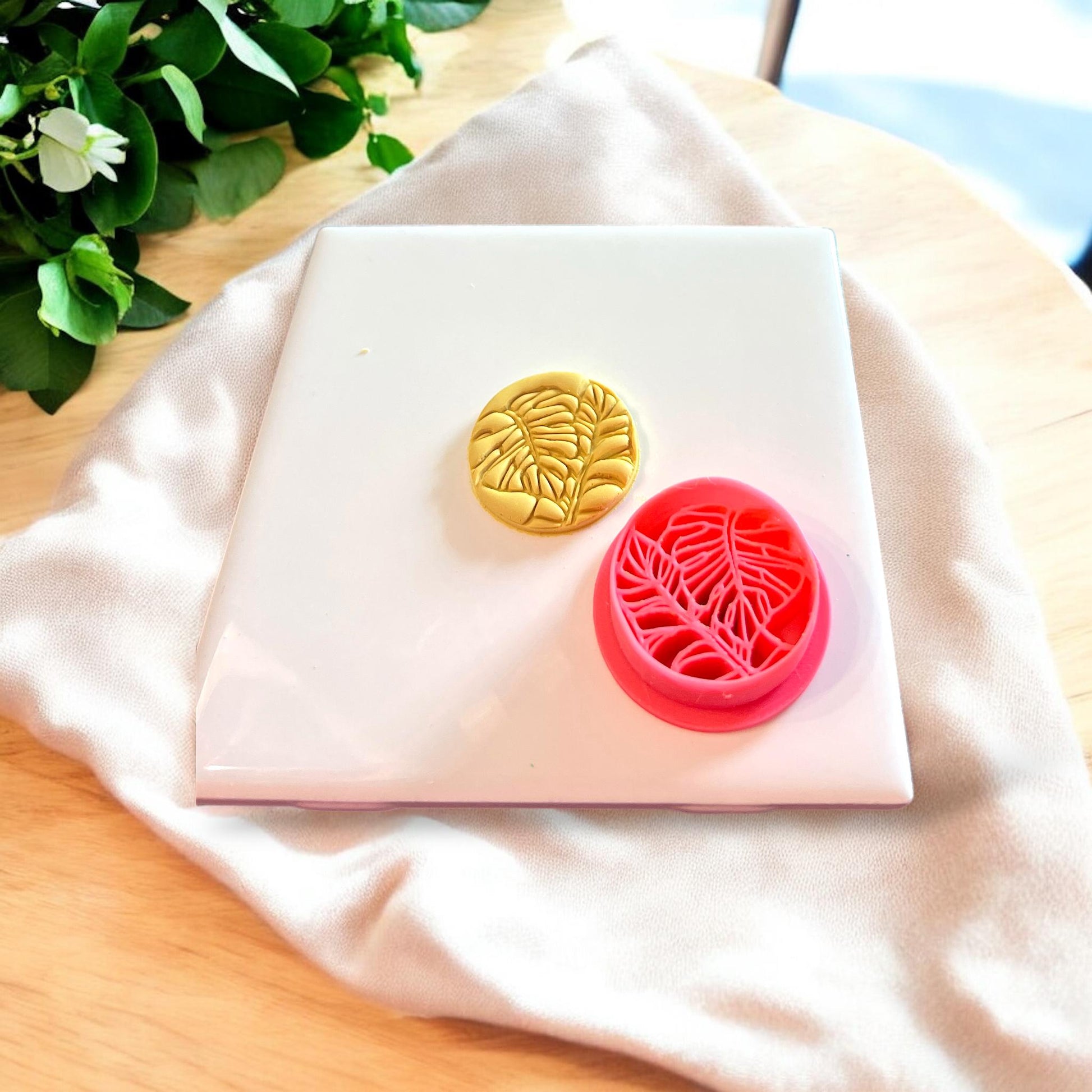 Monstera leaf cutter showcasing its use in polymer clay jewelry creation.