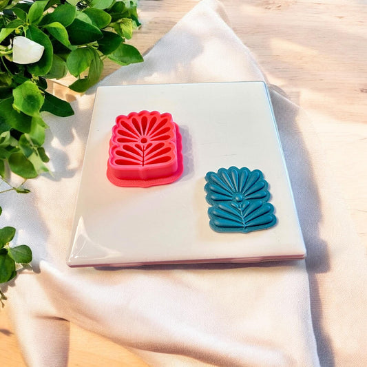 Red Scandinavian flower cutter resting on tile, showing the bold folk arch design in full detail