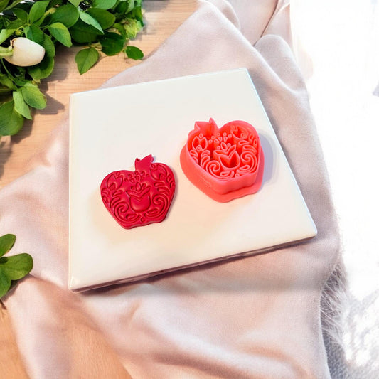 Red floral apple polymer clay shape beside matching folk cutter with tulip elements