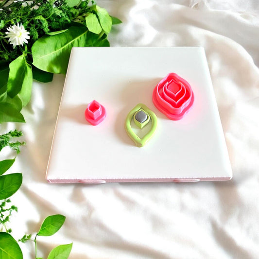 Jewel drop cutters, green and gray clay cutouts, and full cutter set displayed for size comparison on white tile