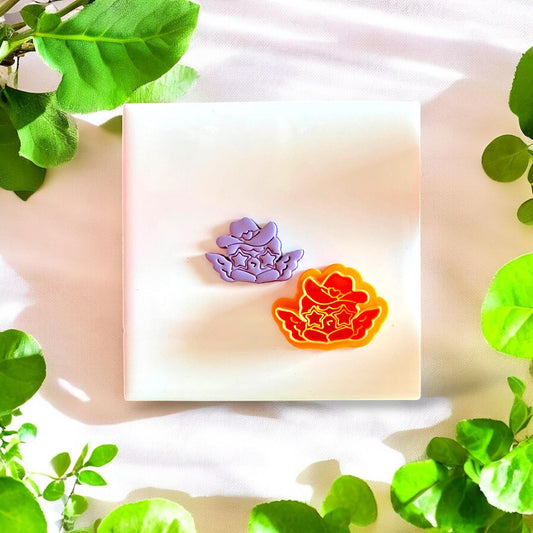 Completed polymer clay earrings made using the western cupid cutter, displayed on a neutral background.