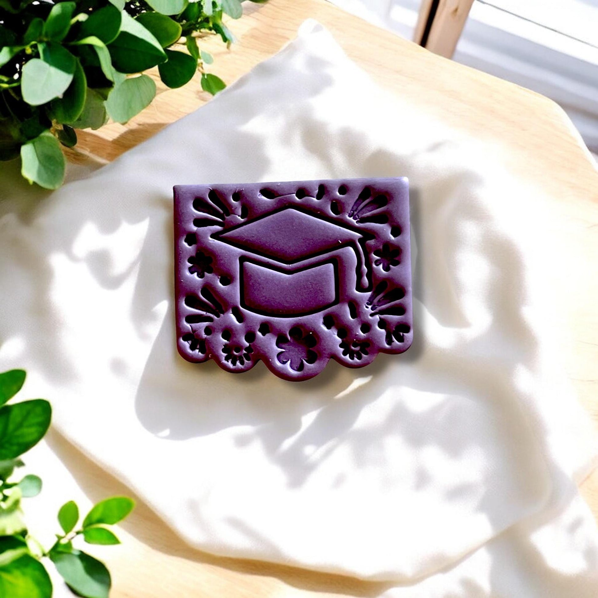 Grad cap cutter and finished clay piece