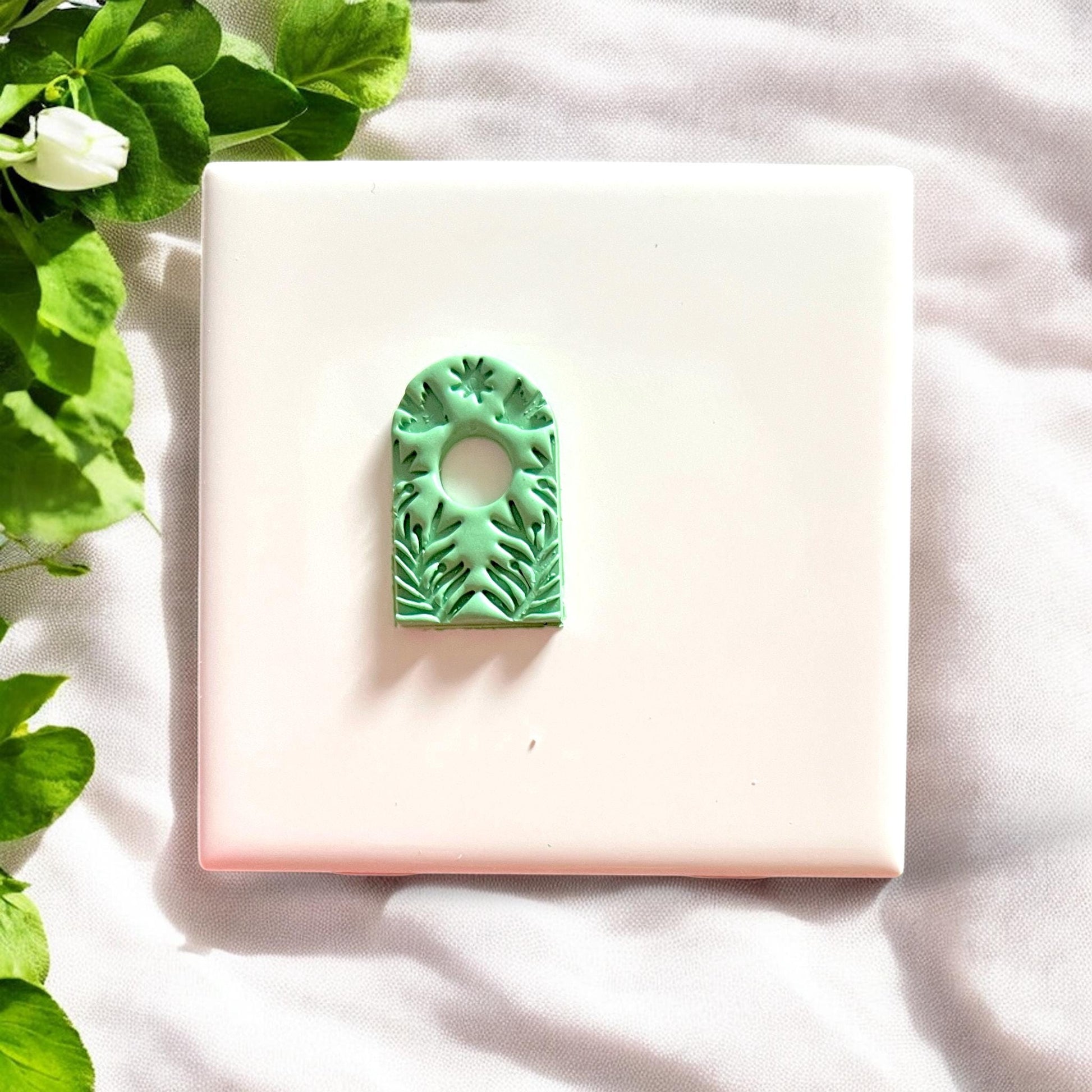 Cut-out boho arch earring piece with circular center and leaf details