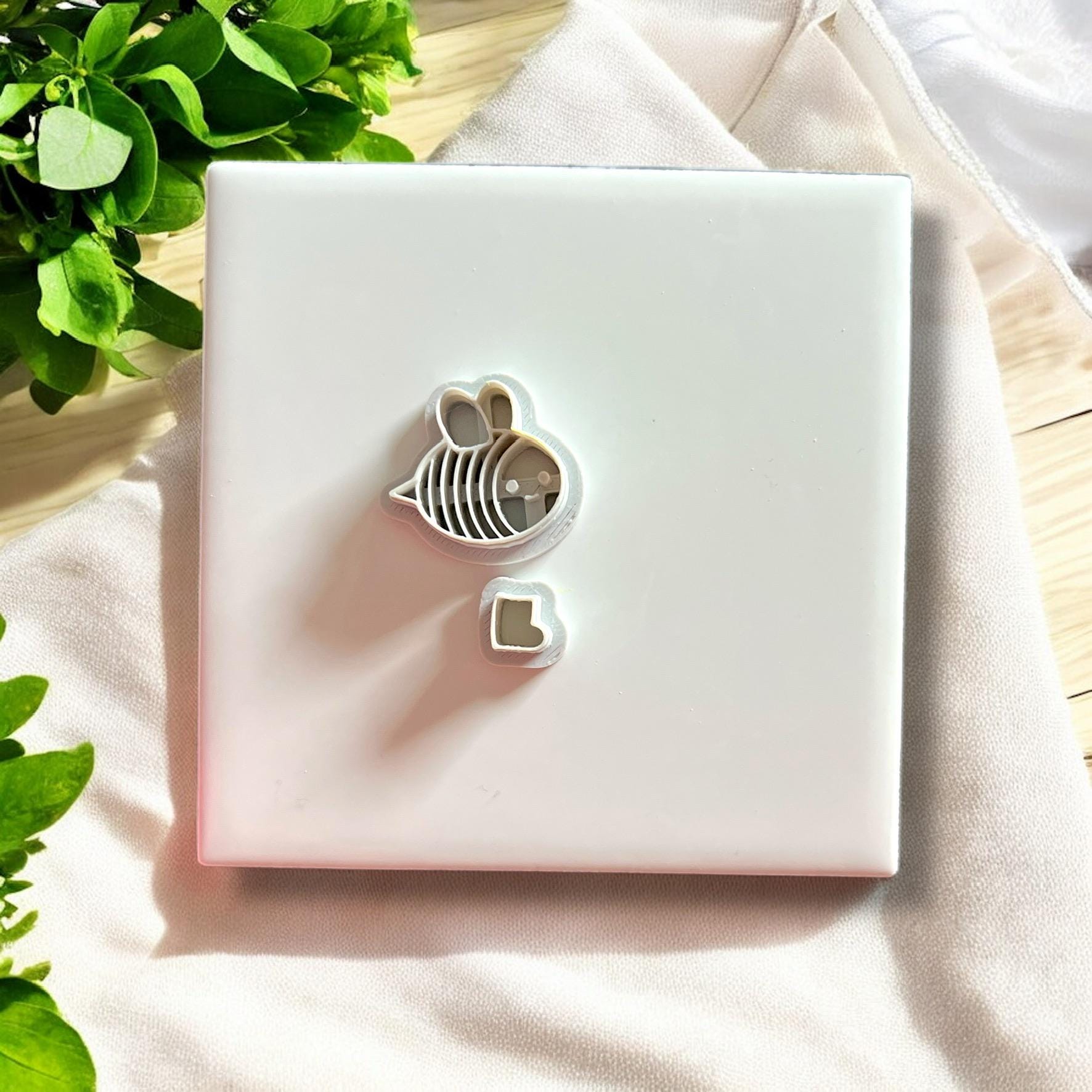 The full bee clay cutter set including body and boot cutters displayed neatly on a white tile surface.