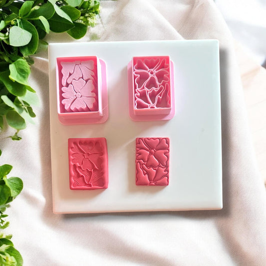 Completed polymer clay earrings made using the Matisse flower cutter, displayed on a neutral background.
